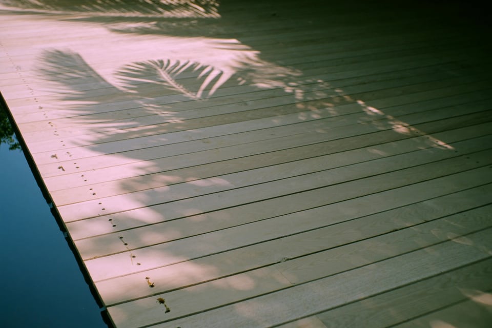 Teak decking with palm shadows — detail from a Cambodian island villa