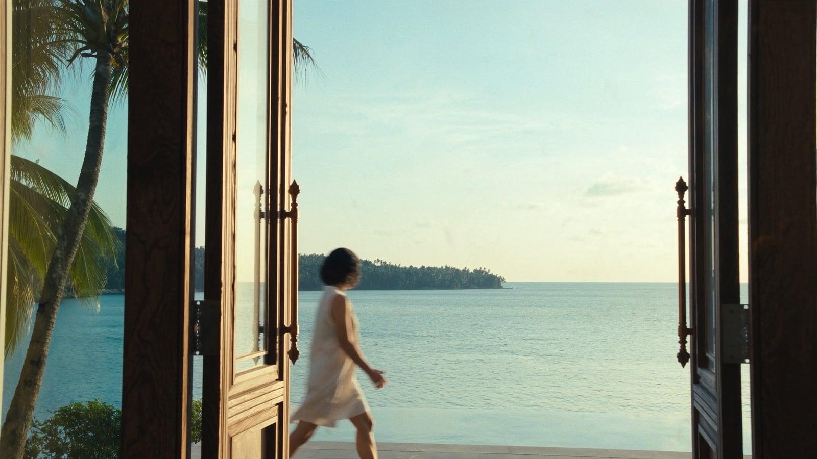 Villa terrace opening onto an infinity pool and the Gulf of Thailand at golden hour